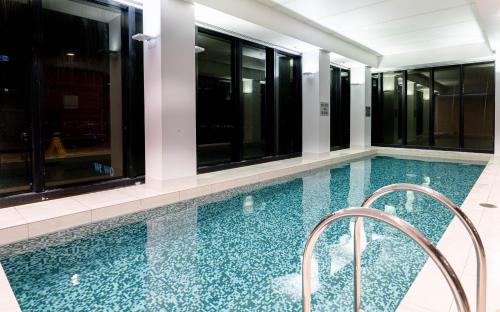 a swimming pool in a building with windows at Luxury Collins St Apartment- 2BR w Balcony- High Floor in Melbourne