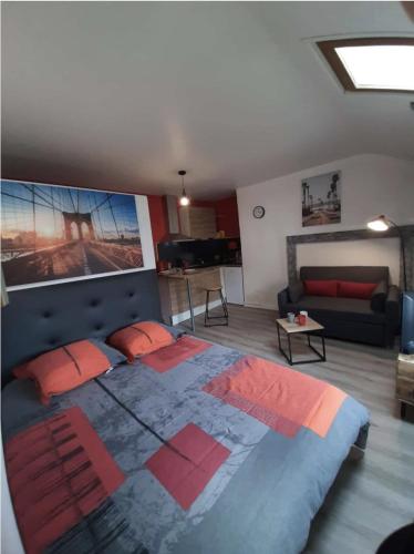 une chambre avec un grand lit et un salon dans l'établissement La cour de Jeanne studio centre ville, à Aurillac