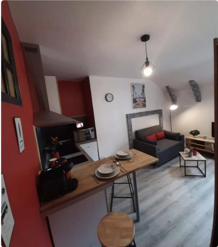 un salon avec une table et un canapé dans l'établissement La cour de Jeanne studio centre ville, à Aurillac