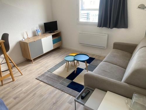 un salon avec un canapé et une table dans l'établissement Studio-Calais Plage-Front de mer, à Calais