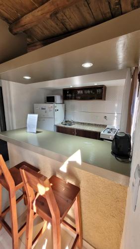 a kitchen with two chairs and a counter with a table at Complejo Atrapasueños in San Rafael