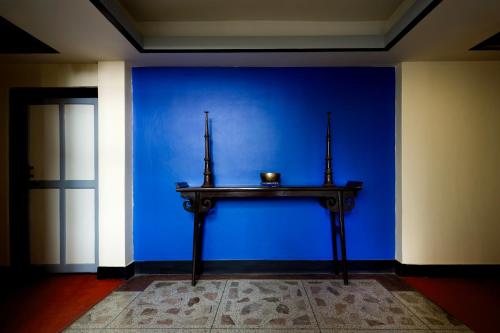 a blue wall with a table with a bowl on it at Shambaling Boutique Hotel in Kathmandu