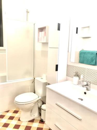 une salle de bain blanche avec des toilettes et un lavabo dans l'établissement Appartement près de Paris 14ème, à Arcueil