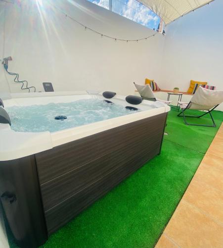 a hot tub in a room with green grass at Casa La via in Camarles