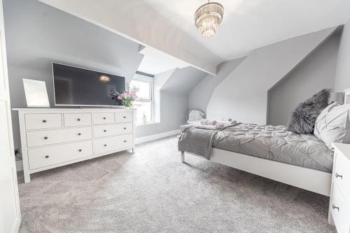 a bedroom with a bed and a dresser with a tv at Luxury townhouse in Workington in Workington