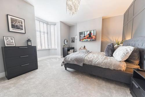 a bedroom with a large bed and a dresser at Luxury townhouse in Workington in Workington