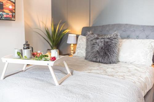 a bed with a tray of food and a table on it at Luxury townhouse in Workington in Workington
