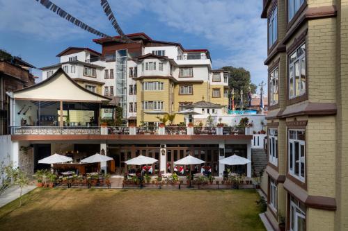 a hotel with a courtyard with tables and umbrellas at Shambaling Boutique Hotel in Kathmandu
