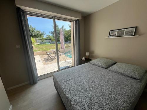 une chambre avec un lit et une grande fenêtre dans l'établissement Havre de douceur avec piscine et jardin, à Éoures