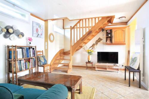 Il comprend un salon avec un escalier et une télévision. dans l'établissement Le logis du port, à Barneville-Carteret