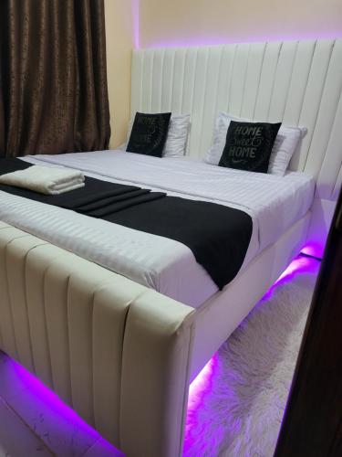 a bedroom with two beds with purple lights at G&G Homes Pioneer 2 Bedroom in Eldoret