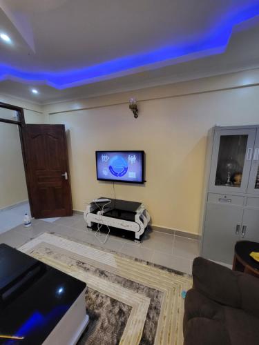 a living room with a flat screen tv on the wall at G&G Homes Pioneer 2 Bedroom in Eldoret