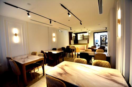 a dining room with tables and chairs and lights at فندق أجنحة ألفية Hotel AJENHA ALFIA in Al Madinah