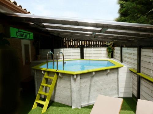 a swimming pool with a yellow ladder next to it at Appartement SAB in Issel