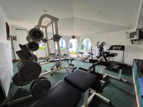 a gym with several treadmills and exercise bikes at Hotel Santo Tomas / Historical Property in San José