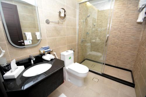 a bathroom with a toilet and a sink and a shower at فندق أجنحة ألفية Hotel AJENHA ALFIA in Al Madinah