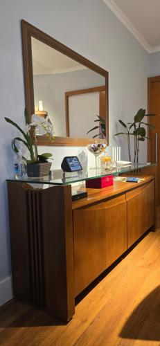 a dresser with a mirror on top of it at Casa Próximo ao Centro Agradável e Inteligente in Poços de Caldas