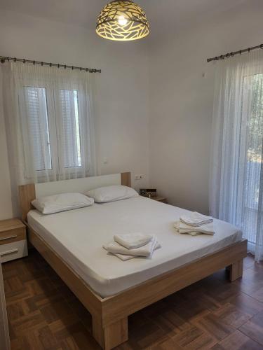 a bedroom with a large bed with two towels on it at Olive Τree Ηouses in Votsalákia