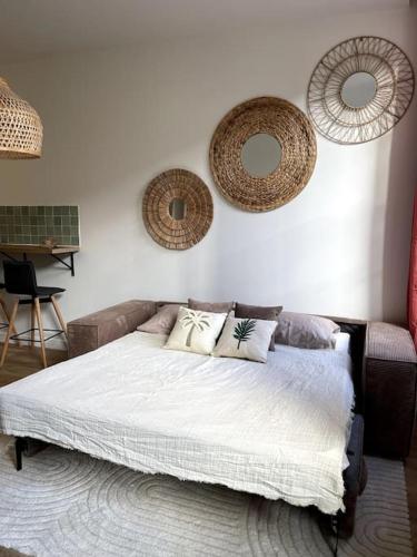 - une chambre avec un lit et deux miroirs sur le mur dans l'établissement Studio au coeur du Vieux Nice - Vue mer et clocher, à Nice