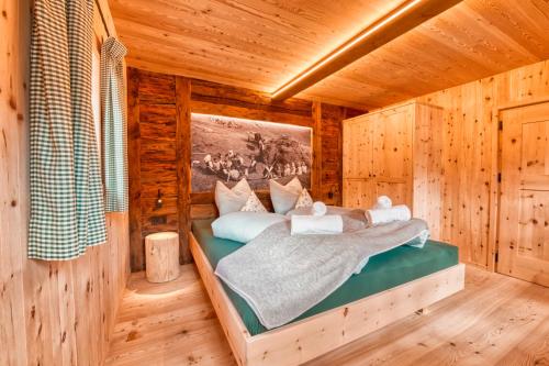 a bedroom with a bed in a log cabin at Finailhof in Madonna