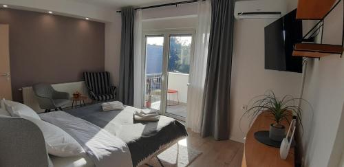 a bedroom with a bed and a view of a balcony at Sunny Residence self check-in in Virovitica