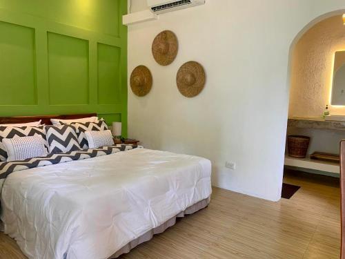 a bedroom with a white bed and green walls at Bakoko Garden in El Nido