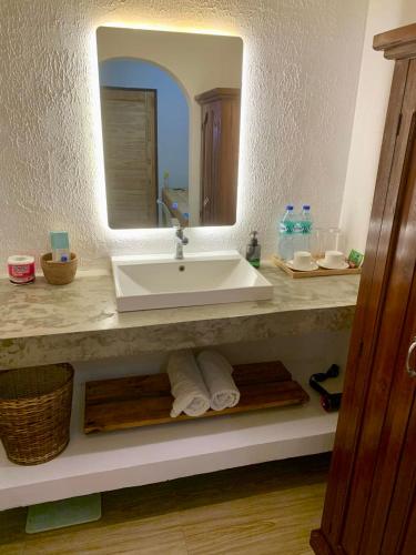 a bathroom with a sink and a mirror at Bakoko Garden in El Nido