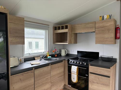 a kitchen with wooden cabinets and a stove top oven at HoneyBees At Glade 17 in Bucks Mills