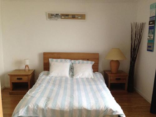 a bedroom with a bed with two night tables and a lamp at Magnifique vue mer, plage & GR34 in Plérin