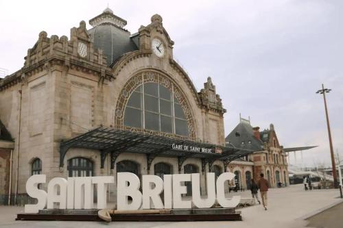 a building with a sant bicycle sign in front of it at Magnifique vue mer, plage & GR34 in Plérin