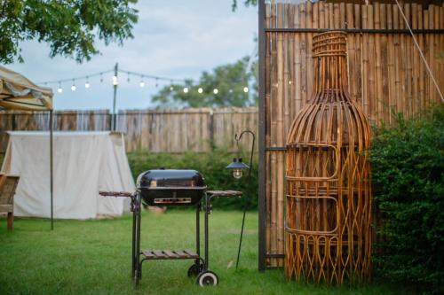 a grill in a yard next to a fence at With you camp in Ban Kham Kom