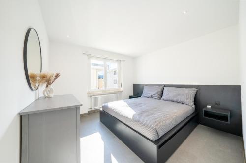 Schlafzimmer mit einem Bett mit einem Spiegel und einem Tisch in der Unterkunft Renovated Lake View Apt with AirCon in Minusio