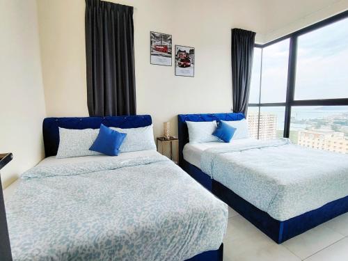 due letti in una stanza con finestra di world premium apartment 3BR pool sea view netflix 14pax a27 a Jelutong