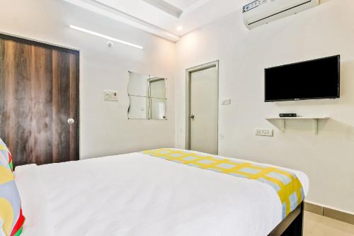 a bedroom with a bed and a flat screen tv at Collection O Vennela Residency in Hyderabad