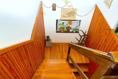 a hallway with wooden stairs and a picture on the wall at Pereszlényi Vendégház in Visegrád