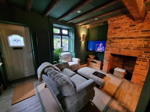 a living room with a couch and a fireplace at Rose Cottage Oulton Leeds in Leeds