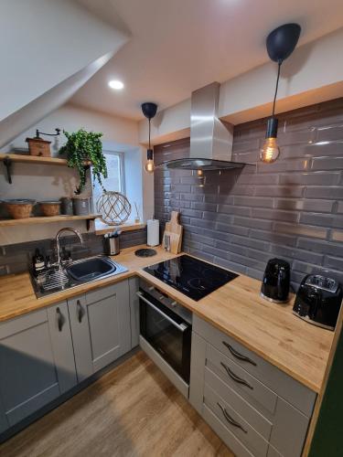 a kitchen with a sink and a stove top oven at Rose Cottage Oulton Leeds in Leeds