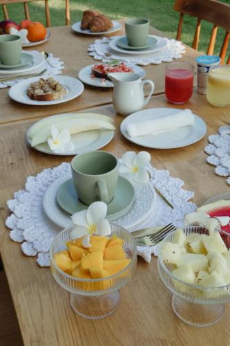 a wooden table with plates of food and cups on it at Pousada Vila Flow in Cumbuco