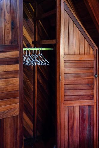 a door to a wooden cabin with a hanger at FLOR DE PARAISO BUNGALOWS in Montezuma