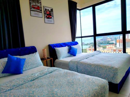 due letti in una stanza con una grande finestra di world premium apartment 3BR pool sea view netflix 14pax a27 a Jelutong