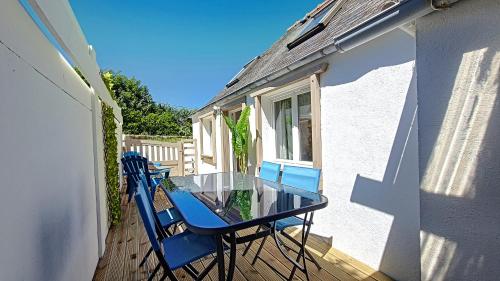 une table et des chaises en verre sur le balcon d'une maison dans l'établissement Pen Ty Armor maison de pêcheur proche mer au calme, à Trébeurden