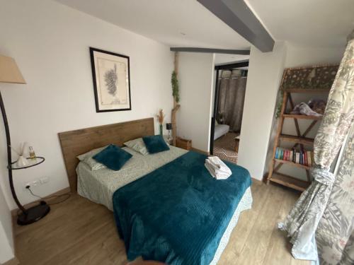 une chambre avec un lit avec des draps bleus et un miroir dans l'établissement charmant T2 centre cassis avec parking, à Cassis