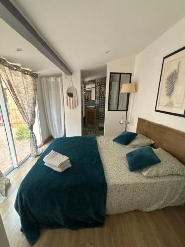 une chambre avec un grand lit avec des draps et des oreillers bleus dans l'établissement charmant T2 centre cassis avec parking, à Cassis