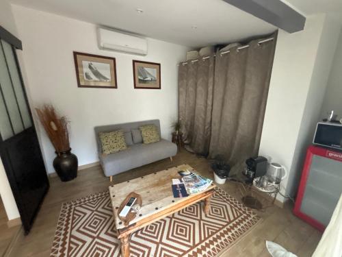 un salon avec un canapé et une table basse dans l'établissement charmant T2 centre cassis avec parking, à Cassis