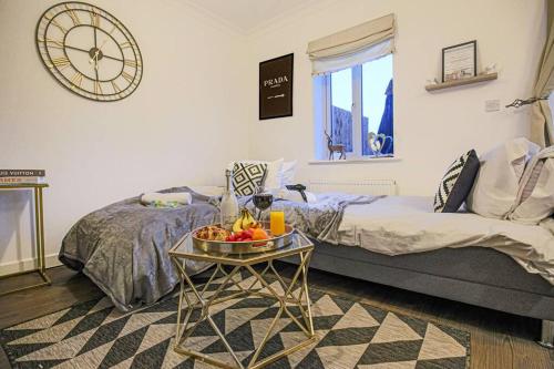 a room with a bed and a table with fruit on it at Stylish House with Smart TVs and Netflix, Fast Wifi, Free Parking and Garden by Yoko Property in Milton Keynes