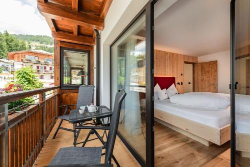 a bedroom with a bed and a table on a balcony at Chalet Rudla in Sesto