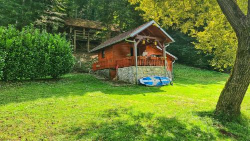 a log cabin with a porch and a boat in a yard at Holiday Home Radočaj in Slunj