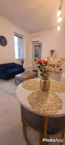un salon avec une table avec un vase de fleurs dessus dans l'établissement Appartement cosy moderne calme hyper centre gare sncf, à Nice