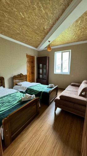 a bedroom with two beds and a couch in it at Farielli Guesthouse in Mestia