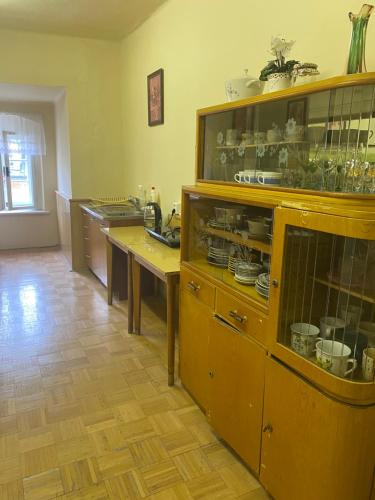 a kitchen with wooden cabinets and tables in a room at Zámek Hošťálkovy in Hošťálkovy